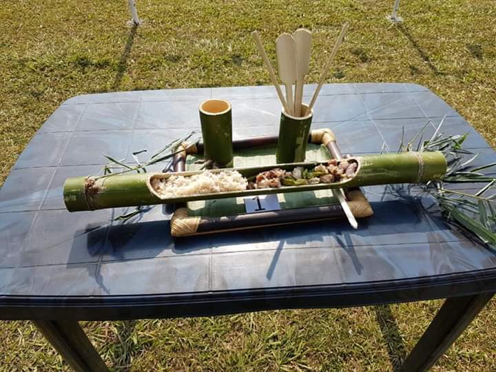 Garo feast dishes served in split bamboo and bamboo tubes on a table