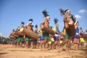 Wangala festival: Garo dancers in feathered headgear carrying long dama drums at the 44th Wangala Festival, Meghalaya